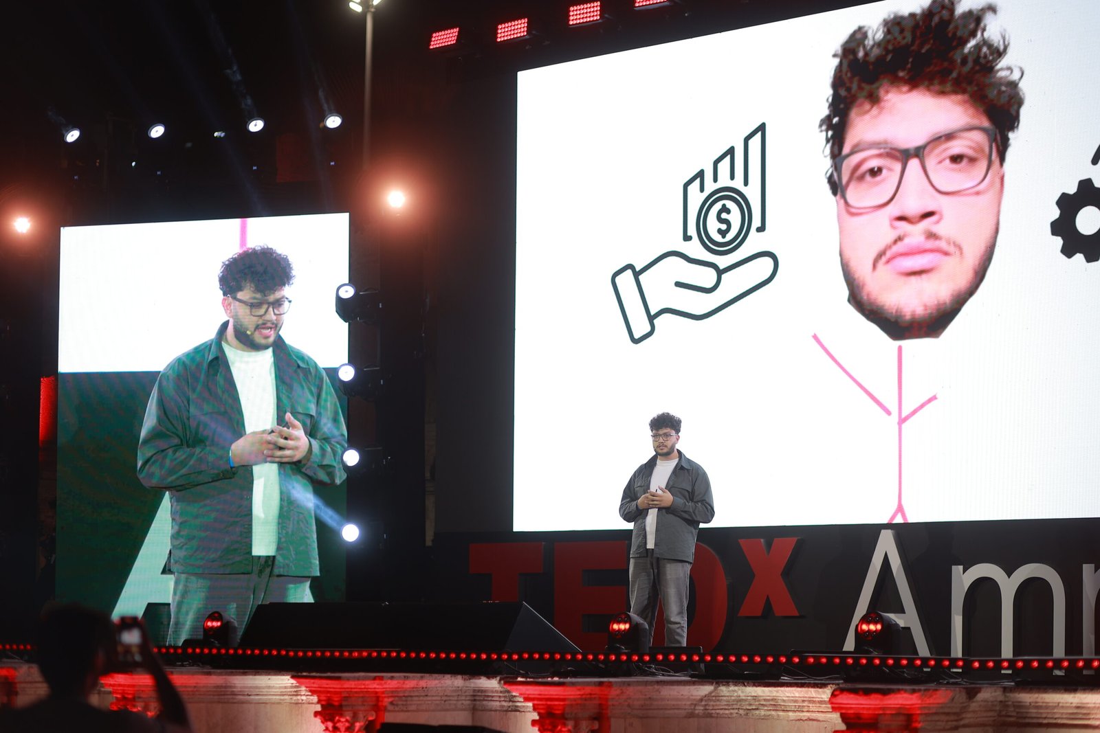 Keynote speaker presenting on large stage with big screen