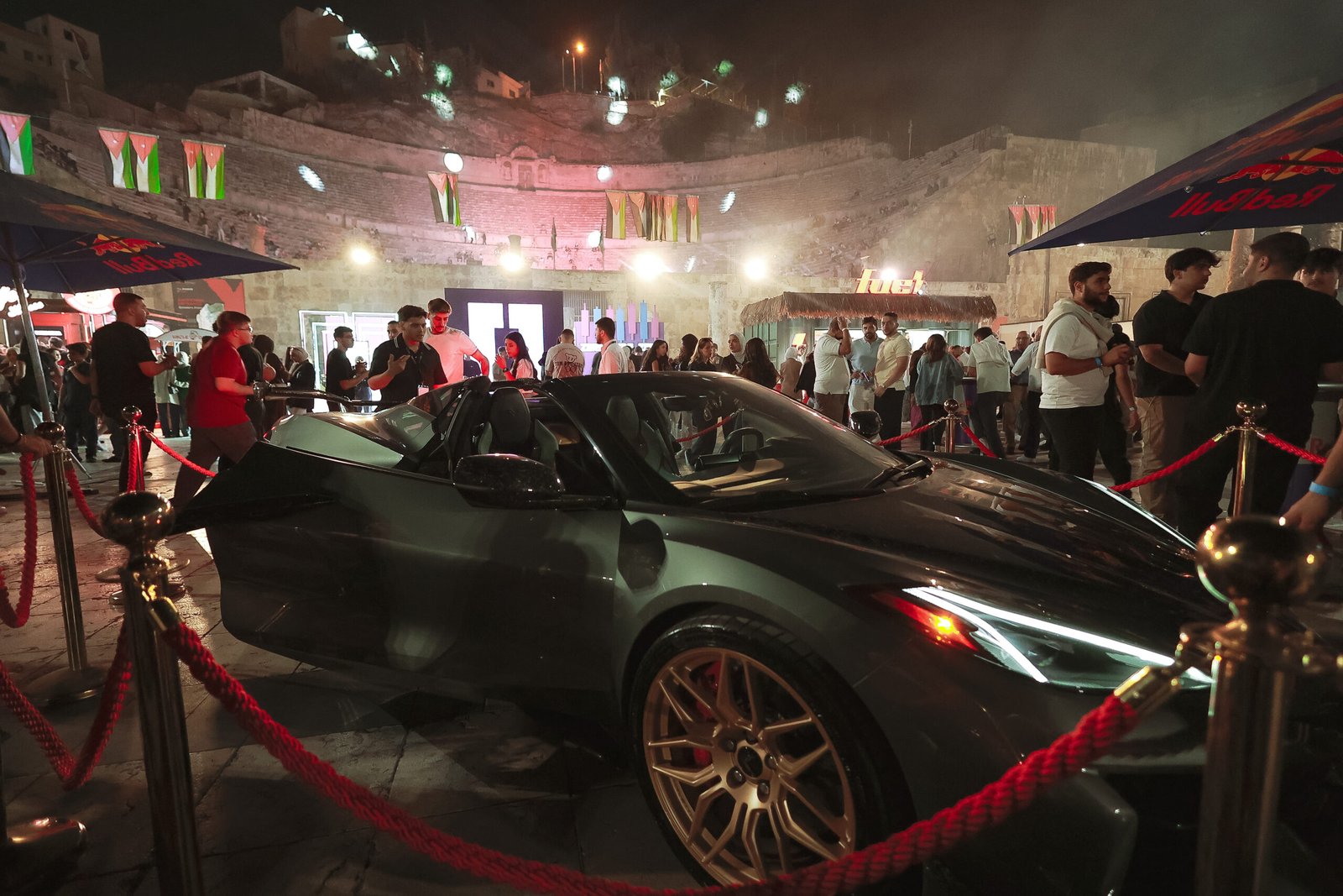 Luxury sports car displayed at outdoor automotive event with crowd