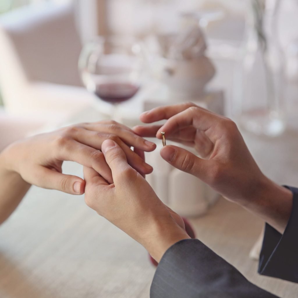 Man making marriage proposal to girlfriend at restaurant, closeup